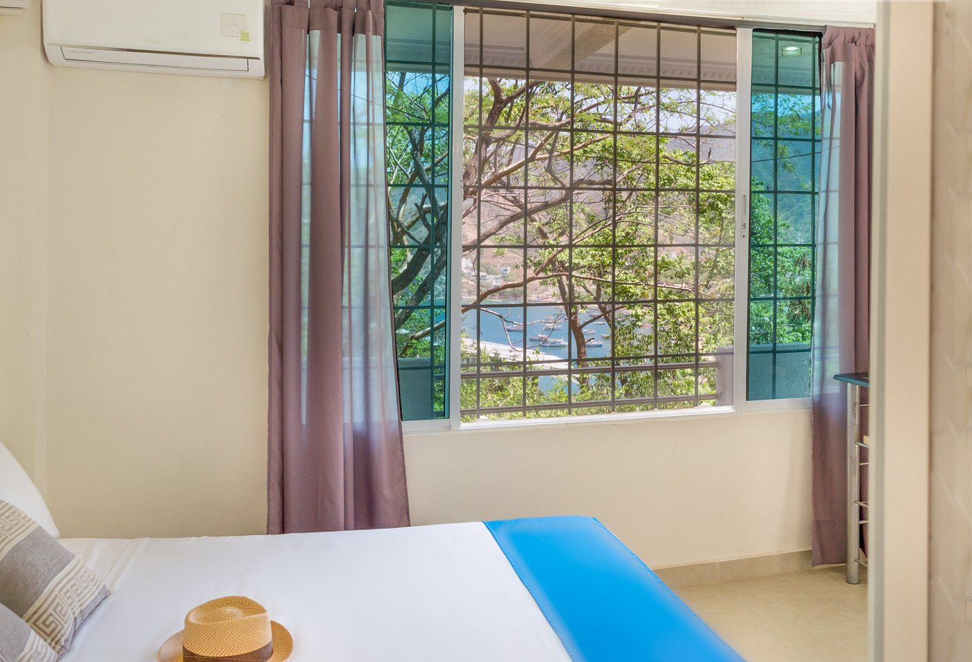 Habitación de alojamiento turístico con ventana y vistas al mar de la bahía